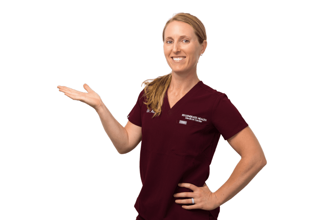 Female practitioner in burgundy scrubs smiling in professional horizontal portrait with her hand raised