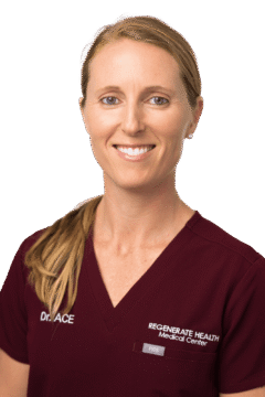 Medical practitioner in burgundy scrubs smiling in a vertical staff headshot
