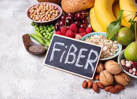 Assortment of high-fiber foods including fruit, legumes, and nuts